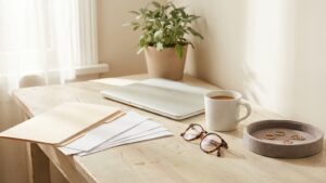 A small business owner desk with a paperwork folder, laptop and a velvet tray of jewelry samples
